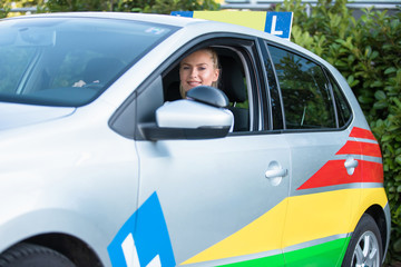 Young woman driving student sitting in a car
