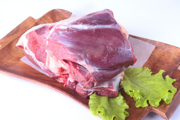 Raw beef shanks and lettuce leaf on wooden desk isolated on white background from above and copy space. ready for cooking.