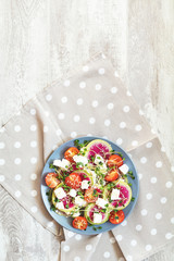 Healthy delicious tasty salad with tomatoes, radishes, cheeses, sprouts and sesame in plate