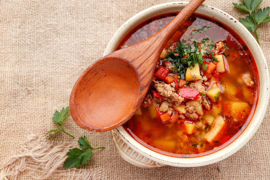 Bulgarian potato soup with paprika and minced meat in a ceramic bowl