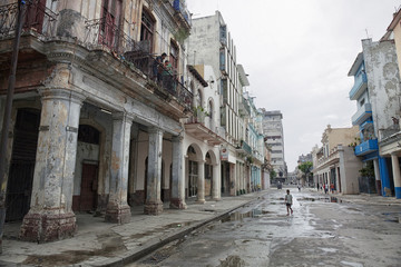 Old buildings and walking people on the street of old La Havana city