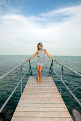 Young woman standing on the pier at the lake