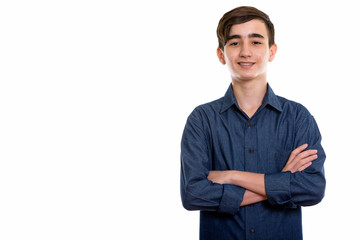 Studio shot of young happy Persian teenage boy smiling with arms