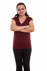 Studio shot of mature Persian woman standing with arms crossed