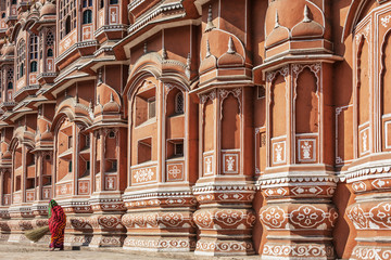 Fototapeta na wymiar Woman in front of Hawa Mahal palace or Palace of the Winds in Jaipur city, India