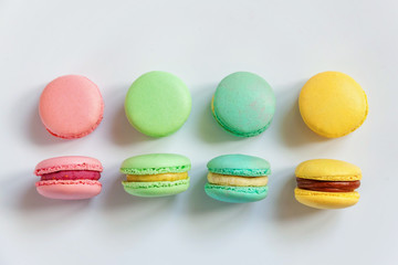 Sweet almond colorful pink, biue, yellow, green macaron or macaroon dessert cake isolated on white background. French sweet cookie. Minimal food bakery concept. Flat lay, top view, copy space