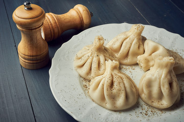 Traditional chinese or asian food, steamed dumpling served on white plate with salt and pepper