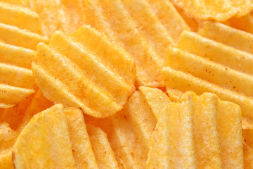 Appetizing peeled chips with paprika. Food chips background. Food Background.