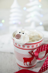Mug with hot chocolate with polar bear marshmallow face with Christmas trees decorations