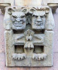 Fototapeta premium Caricature Wall Sculpture Depicting Two Faces With Different Expressions