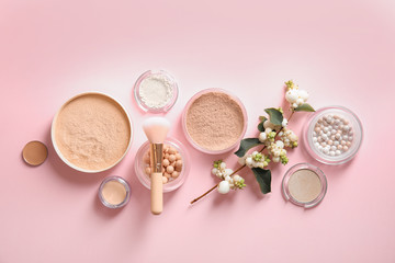 Flat lay composition with various makeup face powders on color background