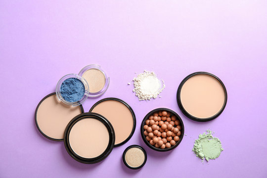 Flat lay composition with various makeup face powders on color background. Space for text