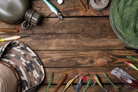 Flat lay composition with fishing equipment and space for text on wooden background
