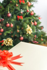Decorated and blurred Christmas tree in the background and front gift box