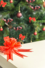 Decorated and blurred Christmas tree in the background and front gift box