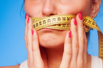Beautiful young woman with a taped tape on the mouth as symbol of diet.