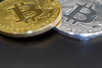 Silver and golden bitcoin on black background