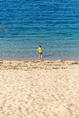 View of boy playing at the water's edge, near the beach, Leça da Palmeira