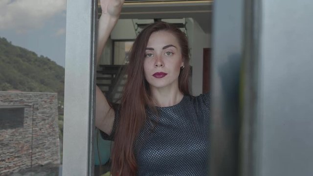 Beautiful red hair girl in elegant dress posing in luxurious modern interior - video in slow motion