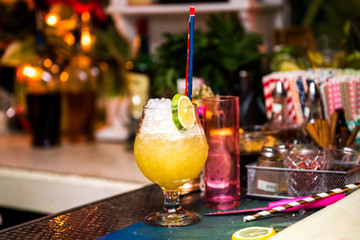 Alcohol refreshing cocktail with ice, liquor and juice in nightclub or bar counter.