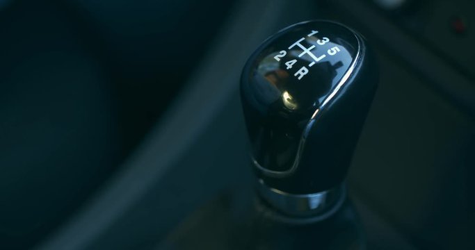 Female hand shifting gear while driving. Closeup footage.