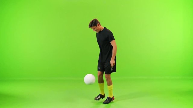 Soccer player play with a ball in a full shot over a green screen. 3 takes, high speed shutter.
