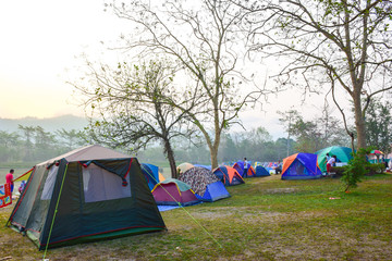 camping tent on the green grass around riverside.