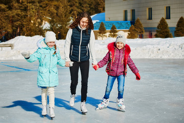 Girls with a coach skate in the winter.