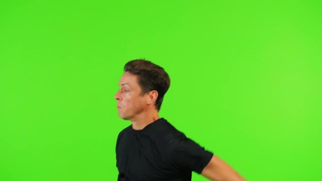 super slow motion Soccer player jumps for a header over a green screen, high speed shutter.