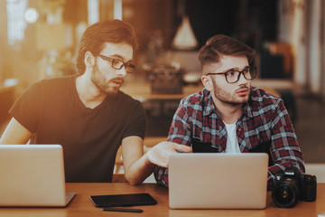 Two Freelance Photographers Work on Laptops