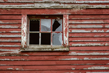 Weathered red paint and broken windows are a common site on barns