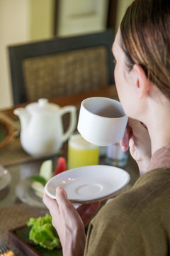 Young woman having the first-morning coffee during breakfast time, the concept of a healthy morning routine lifestyle