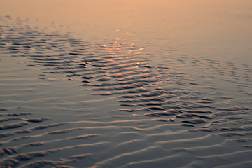 Sunset reflecting on a rippled water surface