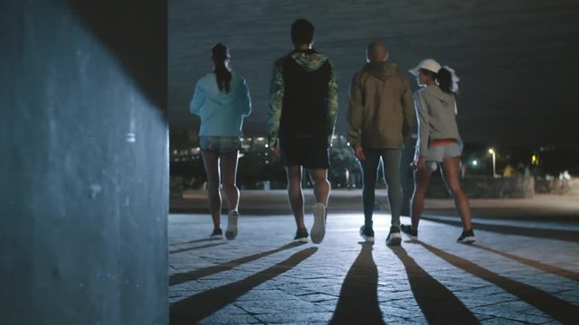 Group of people running in the city at night
