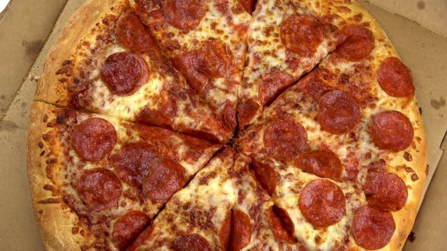 Pepperoni pizza in box spinning video close up