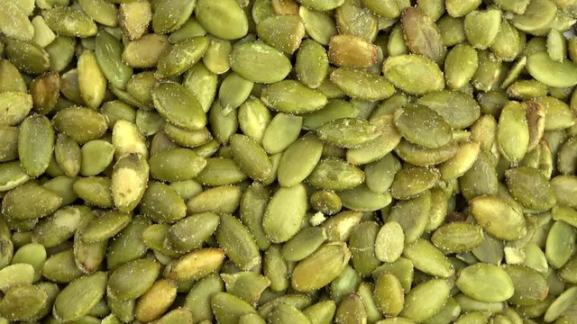 Salted roasted pumpkin seed pepitas spinning video close up