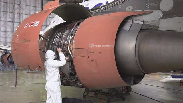 Engine passenger aircraft maintenance. Engineer checks the engine of the aircraft. The repair of aircraft in the hangar. Maintenance of aircraft. Start the jet engine. 4k