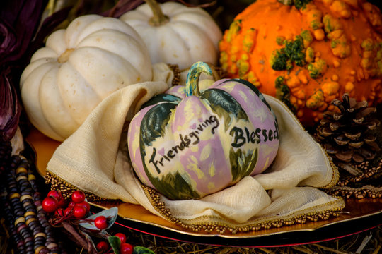 Thanksgiving And Friendsgiving Table Centerpiece With Autumn Harvest Pumpkins In Linen On Table