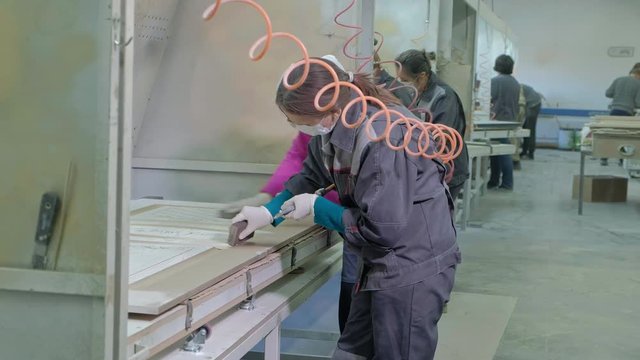 woman, the worker makes the effect of aging doors. production of interior doors from wood