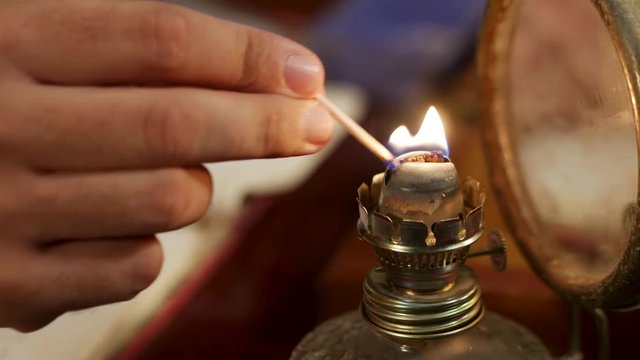 Close-up of using a match to light an old oil lamp