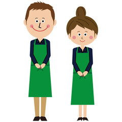 ポップな緑のエプロンをした紺の長袖の男女がお出迎え