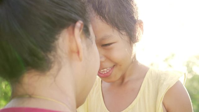 Asian beauty mum and her daughter play in park together. Happy mother's day. Slow motion shot in 50 fps.