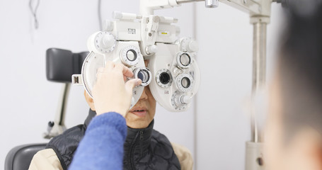 Asian senior man doing eye test