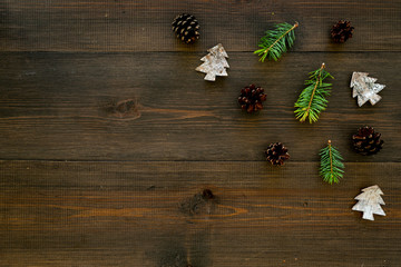 Winter ornament, New Year pattern. Pine sprigs, cones, spruce figure, fir oil on dark wooden background top view copy space