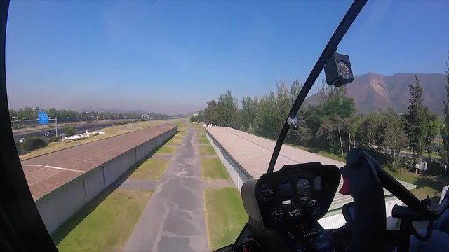 Helicoper flying low in a grass airfield, shoot from the inside, in Full HD at 60fps