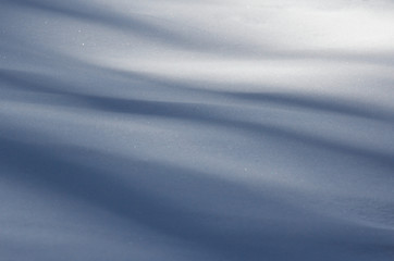 Silky soft velvet abstract shape blue long shadows on the white fresh snow in
