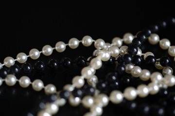 Black and white beads necklace on a dark background close up