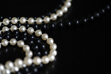 Black and white beads necklace on a dark background close up