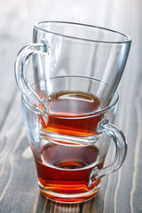 Two tea cups on wooden background. Leftover tea.