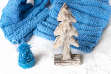 Cristmas tree made from fur with knitted blue hat on the snow cold flat lay